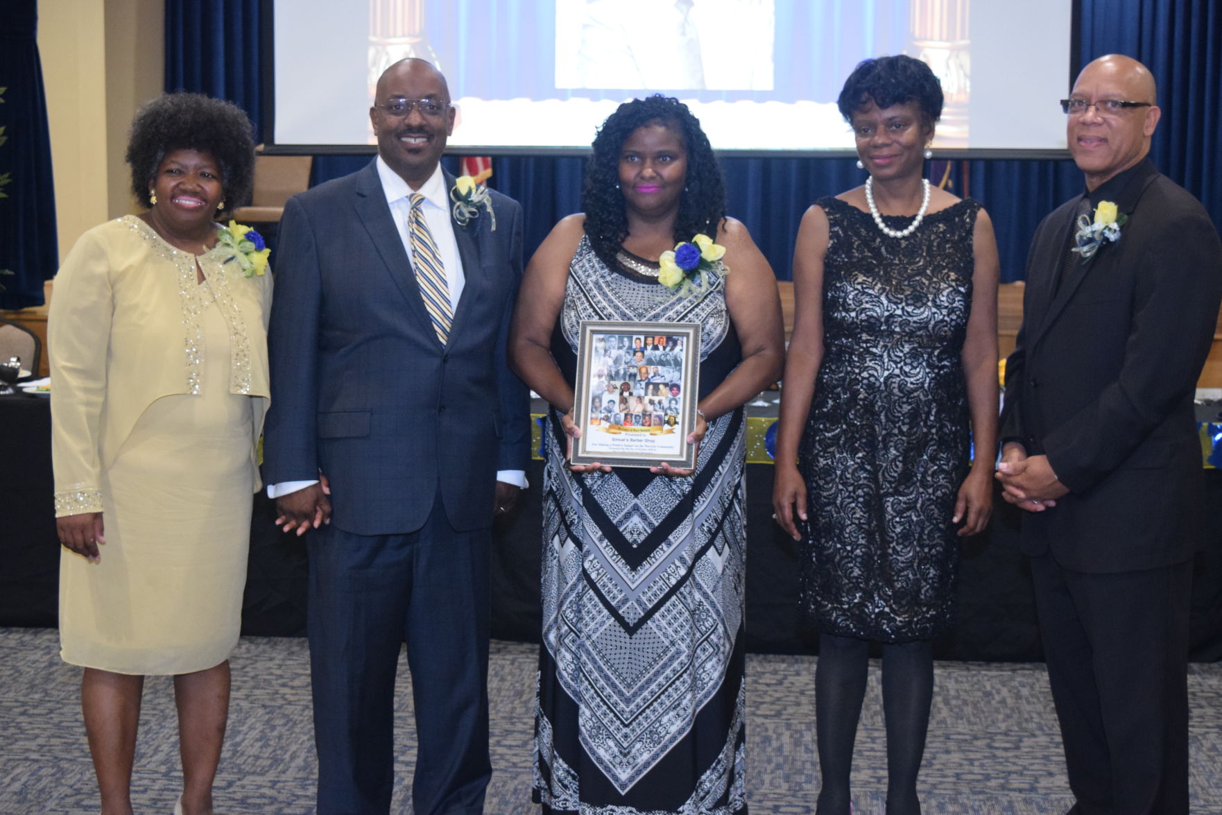 Juvache' Belton accepts Legacy Award for Simuel's Barber Shop.